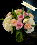 A mix of hydrangea, lilies and carnations in a vase.