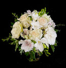 Moderate sized sympathy arrangement, designed with a mix of seasonal blooms and mixed greenery in a vase