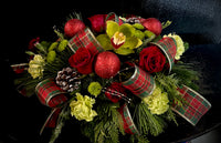 Festive centerpiece with seasonal greenery, fresh blooms , holiday ribbon loops and embellishments.