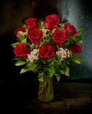 One dozen roses with filler in a vase