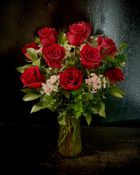 One dozen roses with filler in a vase