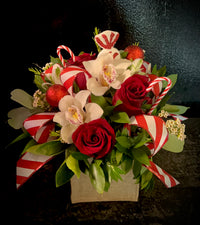 Christmas themed floral box with festive embellishments and seasonal ribbon loops.