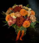 Moderate sized vase arrangement with autumn toned mixed blooms.